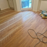 Parkettboden wird mittels Einscheibenmaschine leicht angeschliffen und mit einer neuen Schicht Hartwachs-Öl überarbeitet