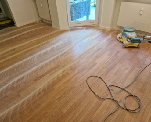 Parkettboden wird mittels Einscheibenmaschine leicht angeschliffen und mit einer neuen Schicht Hartwachs-Öl überarbeitet