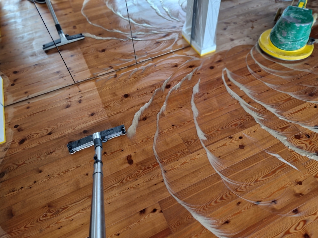 Schmutz wird vom Dielenboden nach der Parkettreinigung abgesaugt